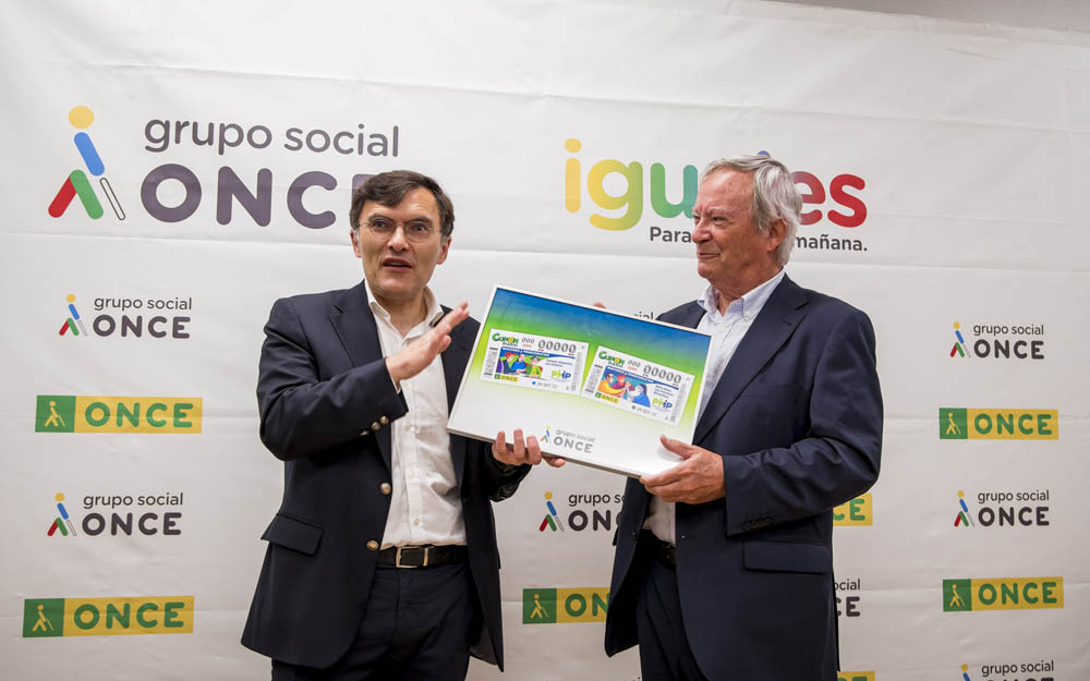 Alberto Durán y Ángel Rodríguez Castedo, durante la presentación del cupón dedicado a las personas mayores Alberto Durán y Ángel Rodríguez Castedo, con una lámina enmarcada del cupón de la ONCE dedicado a las personas mayores.