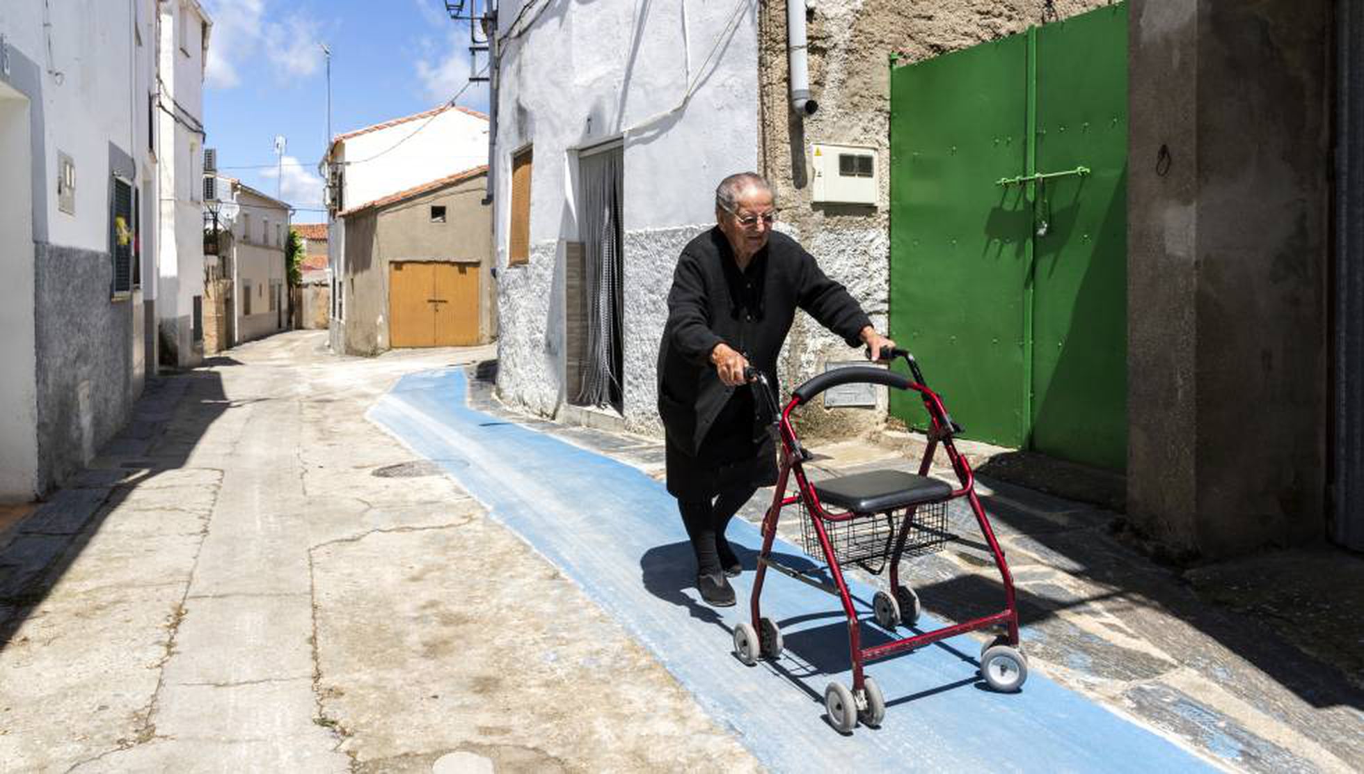 Imagen de una señora mayor paseando por las calles del ueblo