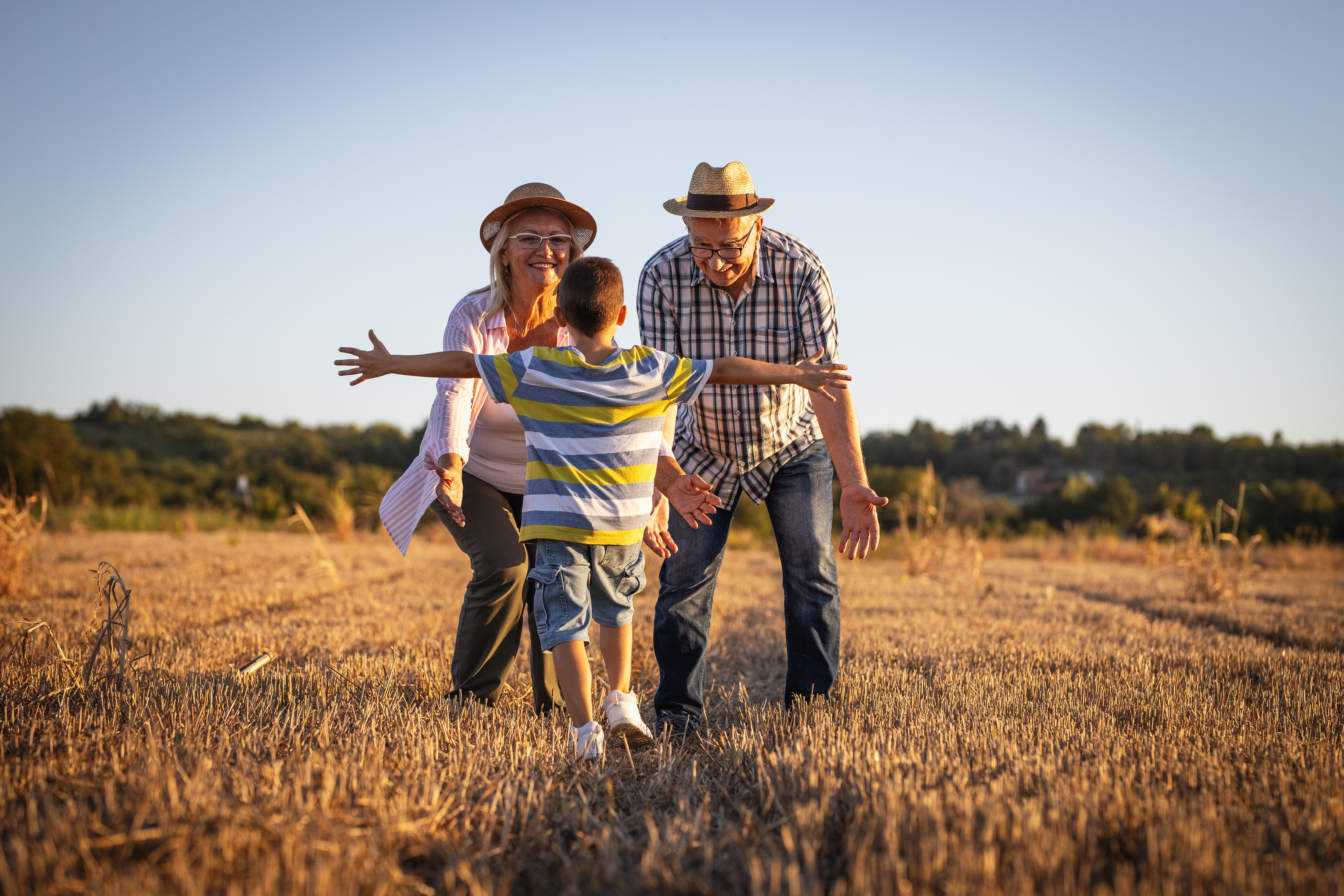 Un abuelo y una abuela con su nieto en el campo