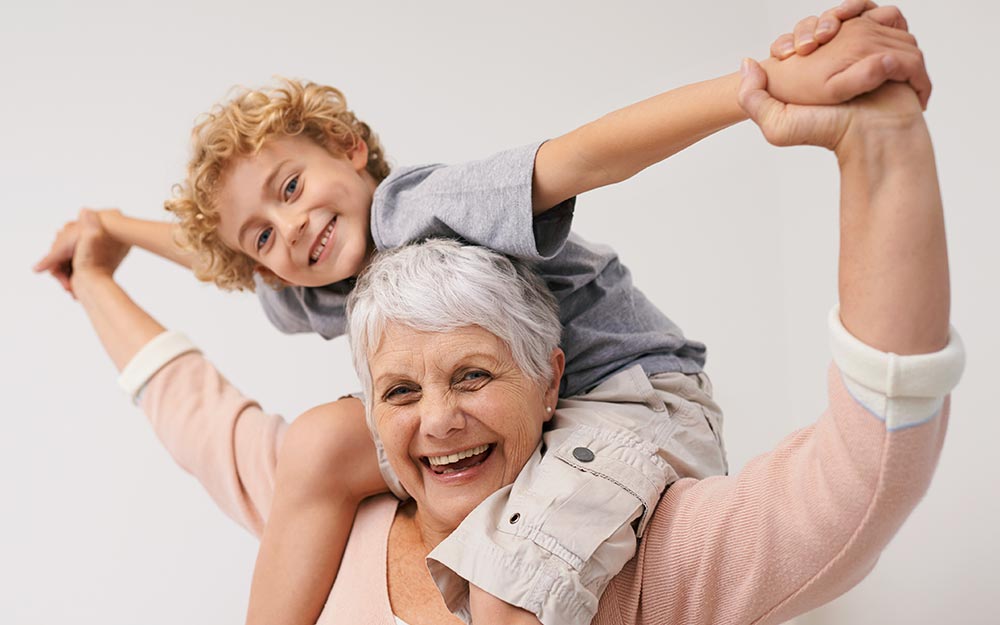 Señora mayor con su nieto subido a los hombros