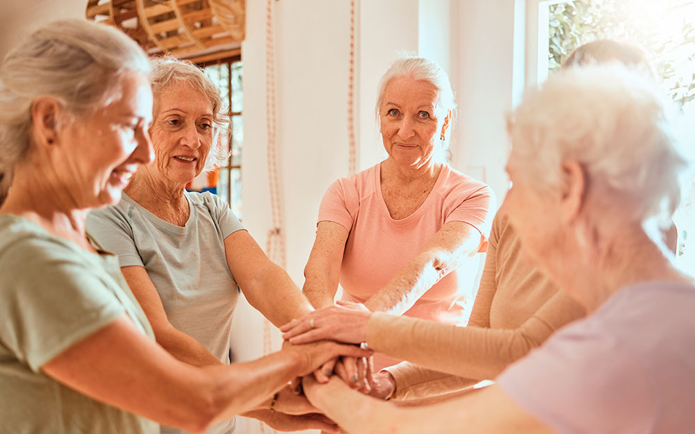 Un corro de mujeres junta sus manos en el centro