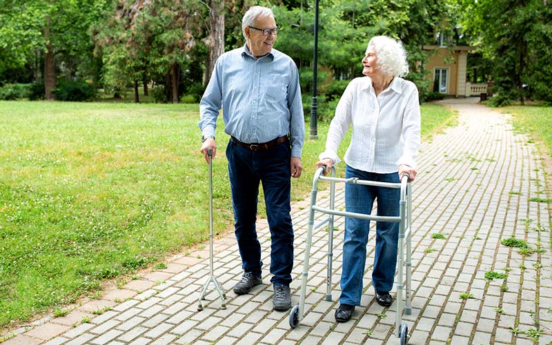 Una pareja de personas mayores camina por un parque