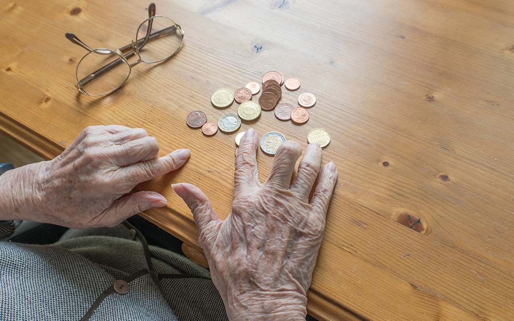 Manos de una persona mayor contando dinero