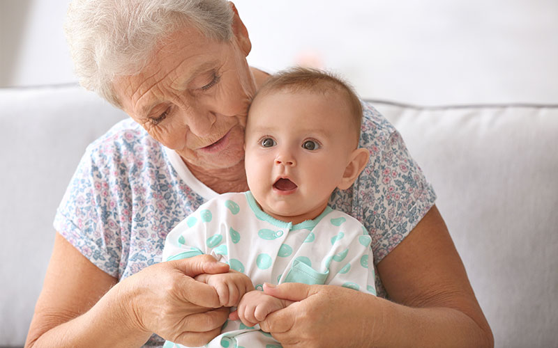 Día de los Abuelos y las Abuelas Una mujer mayor con un bebé en su regazo