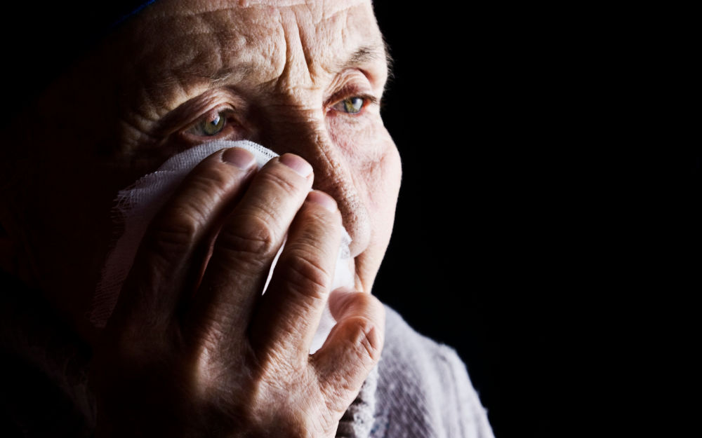 Una mujer mayor se seca las lágrimas