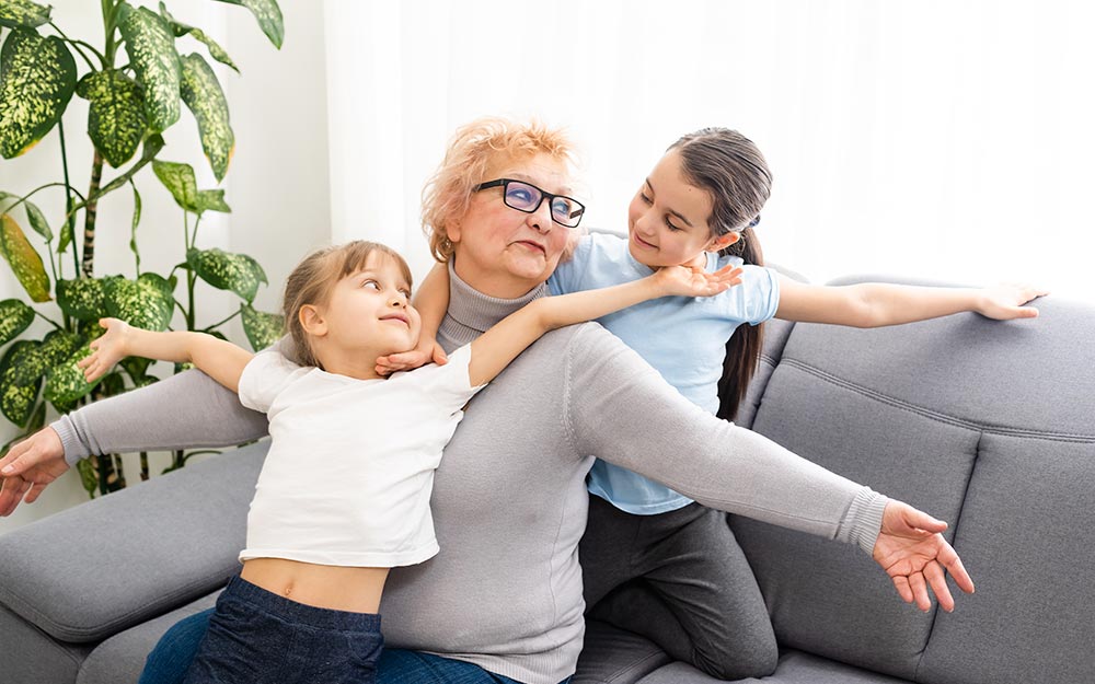 Una mujer juega con sus nietas