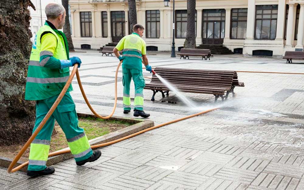 Dos operarios de la limpieza trabajan en la calle.