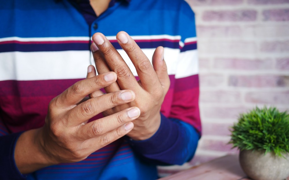 Una persona toca las articulaciones de su mano.