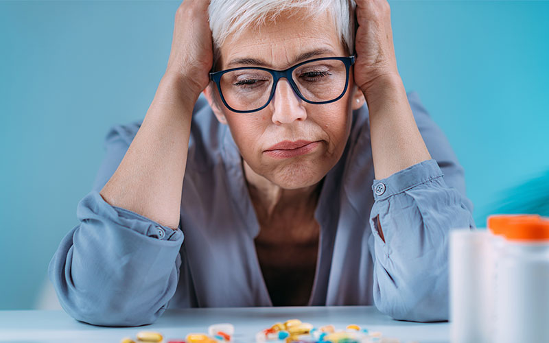 Una mujer observa sus medicinas