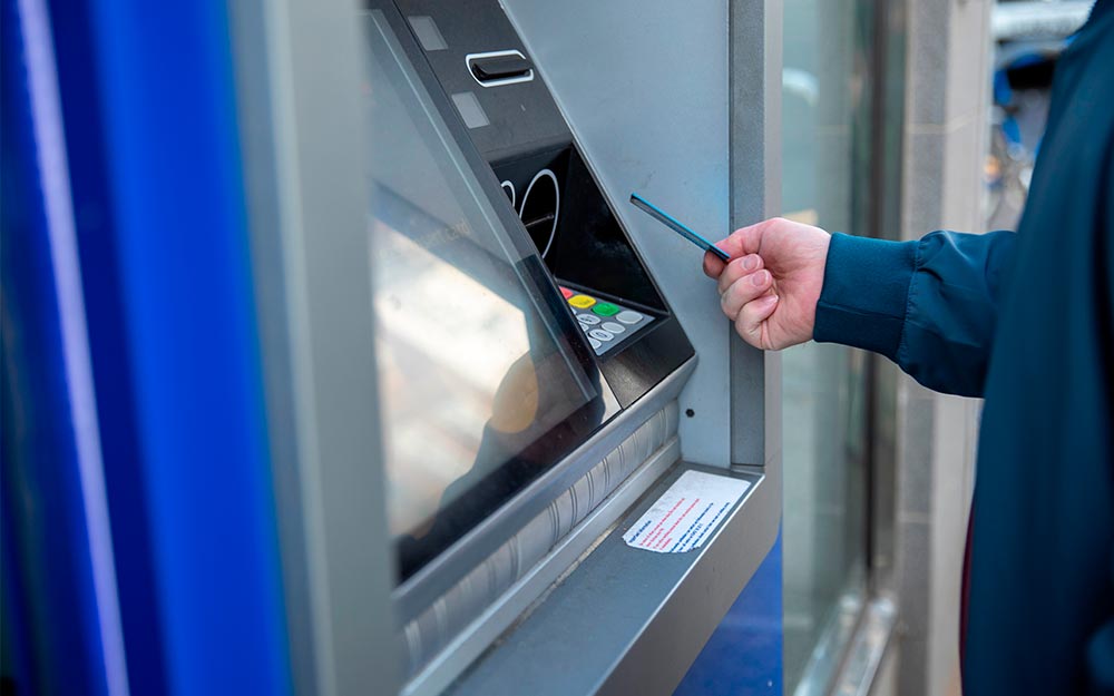 Una persona introduce una tarjeta en un cajero automático