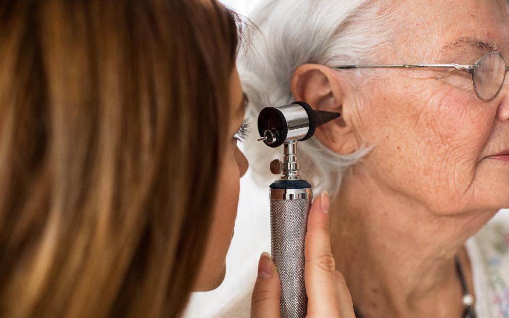 Una persona mayor en una consulta de revisión auditiva 