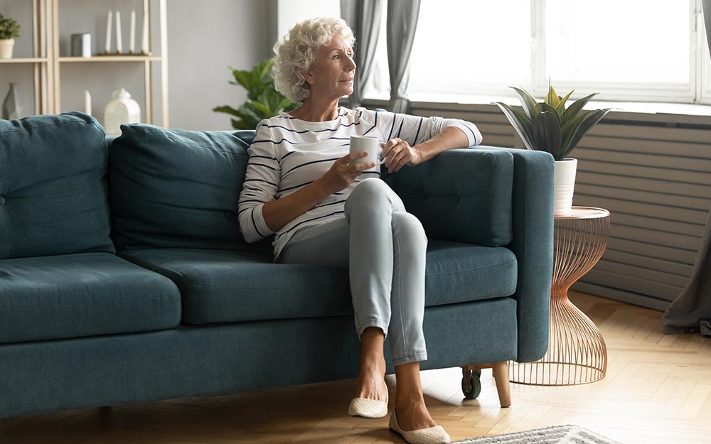 Una mujer sentada en un sofá con una taza