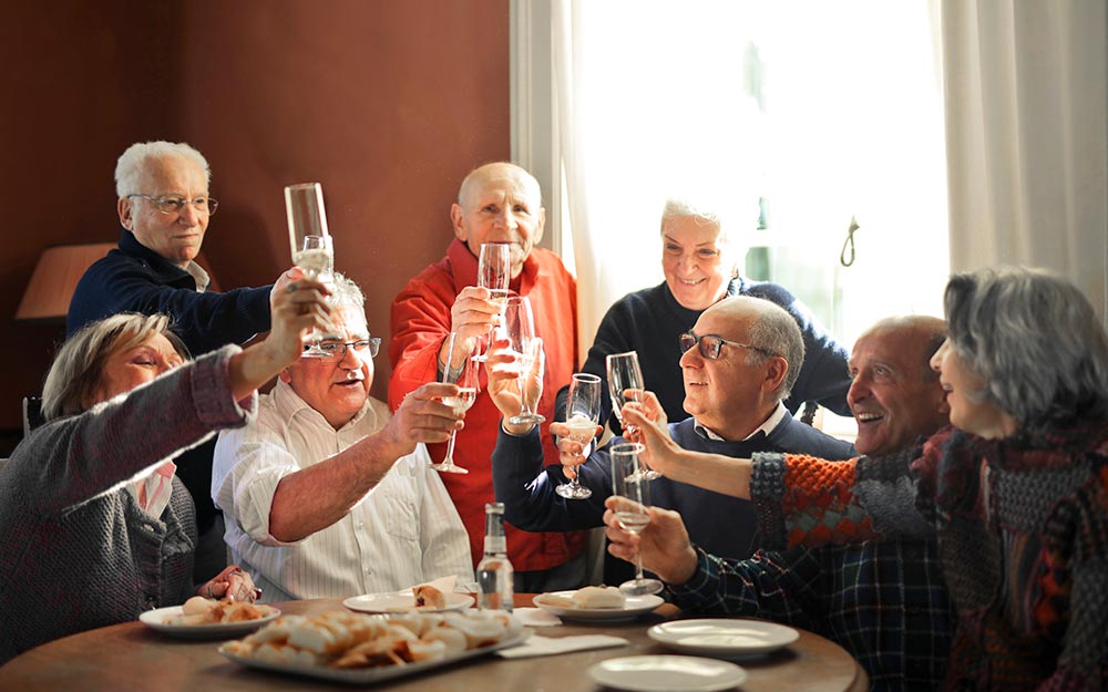Un grupo de personas mayores brindan durante una celebración