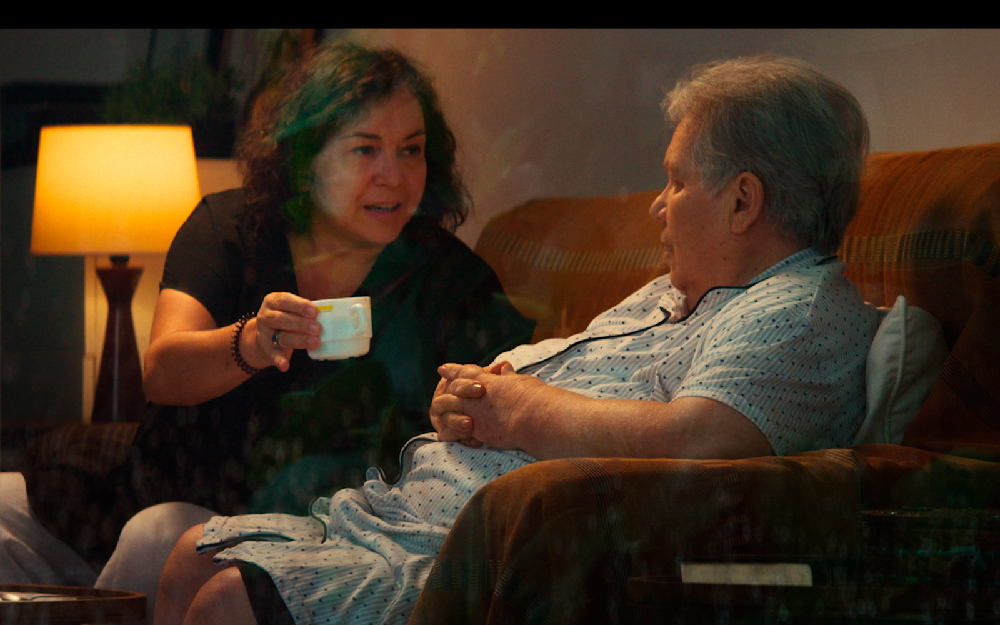 Una señora le ofrece una taza a una mujer mayor