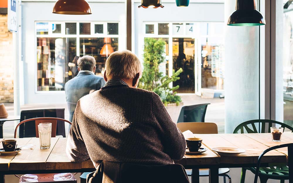 El día elegido tiene que estar comprendido entre los tres meses anteriores o posteriores a la fecha en que se presenta la solicitud Una persona mayor sentada en una cafetería.