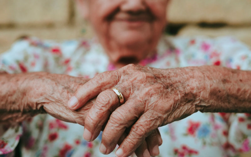 Determina que no se puede aplicar retroactivamente el requisito del registro como pareja de hecho Imagen de las manos de una mujer mayor con una alianza.