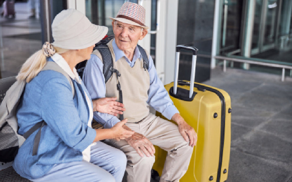 Dos ancianos de viaje con las maletas