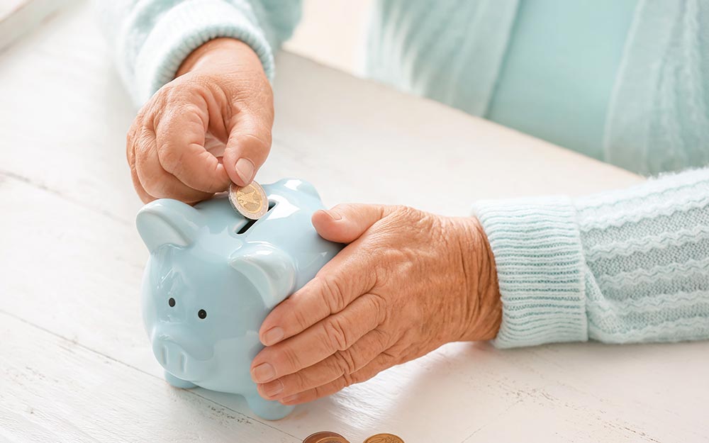 Una persona introduce una moneda en una hucha