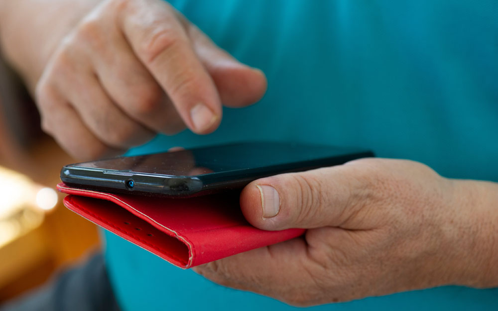 La creciente digitalización de servicios públicos y privados está aumentando la brecha digital Fotografía en la que una persona mayor realiza gestiones con su teléfono móvil.