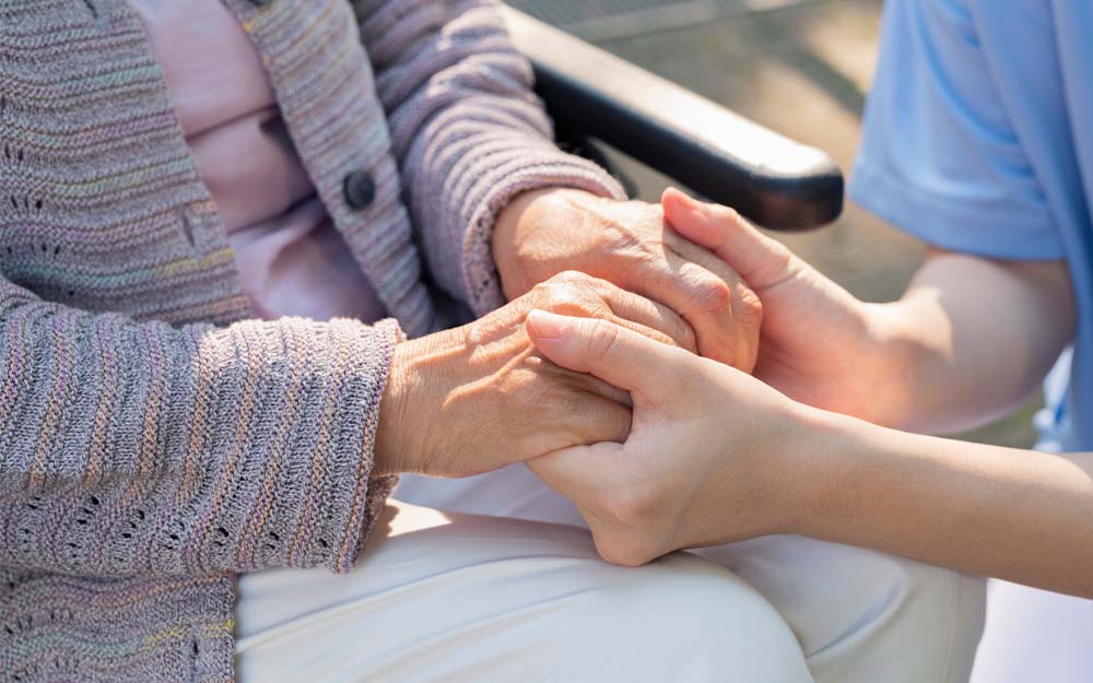 Cada 5 de noviembre se conmemora el Día Internacional de las Personas Cuidadoras Las manos de una personas cuidadora sostienen las de una persona mayor.