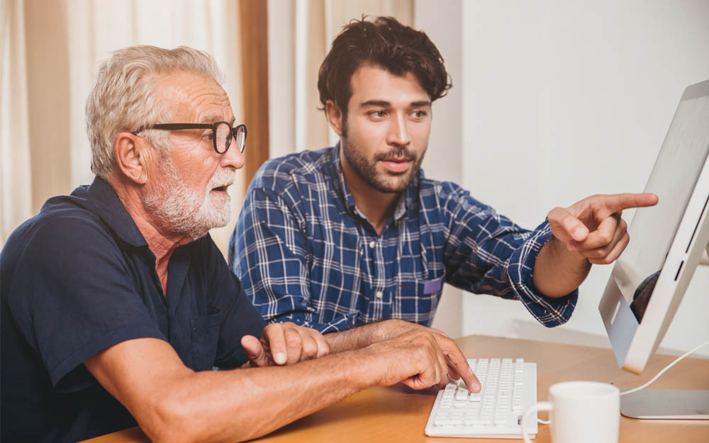 Dos personas, una joven y otra mayor, observan información en la pantalla de un ordenador