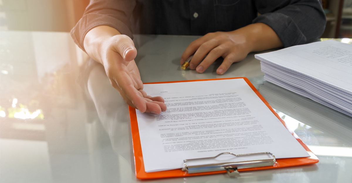 El objetivo del protocolo es mantener la atención presencial en las oficinas de la AEAT para evitar la exclusión de las personas mayores Una persona explica el contenido de un documentación. En la imagen, no se ven las personas que reciben dichas explicaciones.