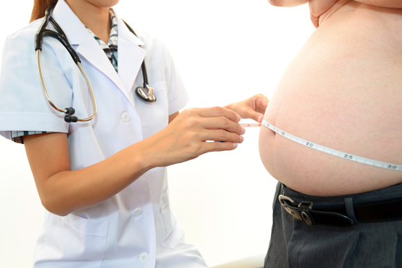 Imagen de una enfermera midiendo la barriga de una persona con obesidad