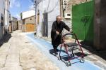 Imagen de una señora mayor paseando por las calles del ueblo