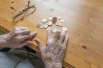 Manos de una persona mayor contando dinero