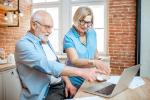 Una pareja de personas mayores consultan información en un ordenador