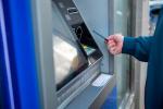 Una persona introduce una tarjeta en un cajero automático