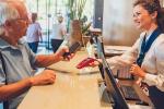 Una persona mayor utiliza su teléfono móvil para realizar un pago