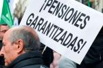 Un apersona en una manifestación sostiene un cartel que dice "Pensiones garantizadas".