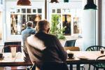 Una persona mayor sentada en una cafetería.