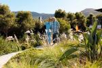 Una médica acompaña a un hombre mayor paseando por un jardín