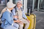 Dos ancianos de viaje con las maletas