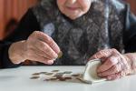 Manos de una persona mayor contando monedas