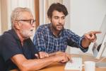 Dos personas, una joven y otra mayor, observan información en la pantalla de un ordenador