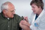 Una enfermera poniendo una inyección a un hombre mayor