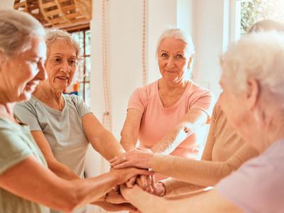 Un corro de mujeres junta sus manos en el centro