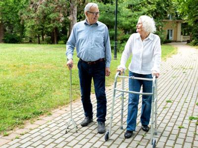 Una pareja de personas mayores camina por un parque