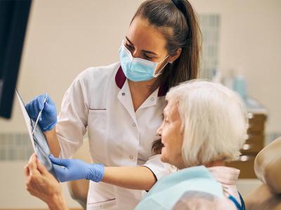 Una mujer mayor es atendida por una odontóloga en la consulta