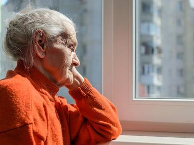 Una mujer mira mira a través de una ventana