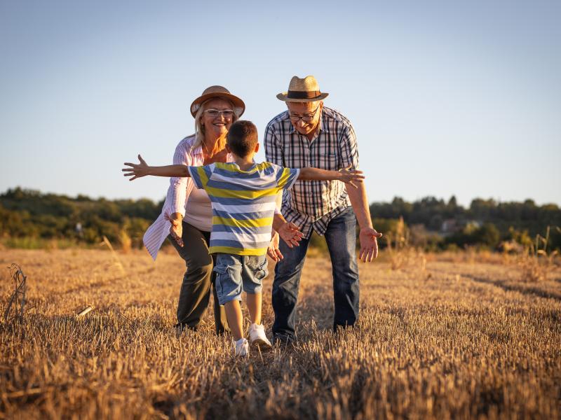 Un abuelo y una abuela con su nieto en el campo