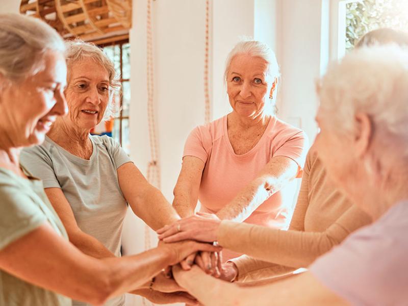 Un corro de mujeres junta sus manos en el centro