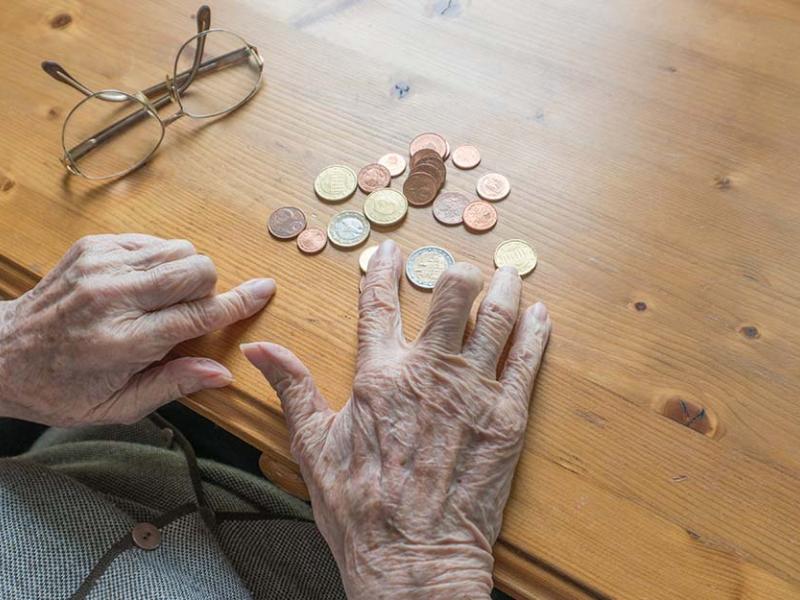 Manos de una persona mayor contando dinero