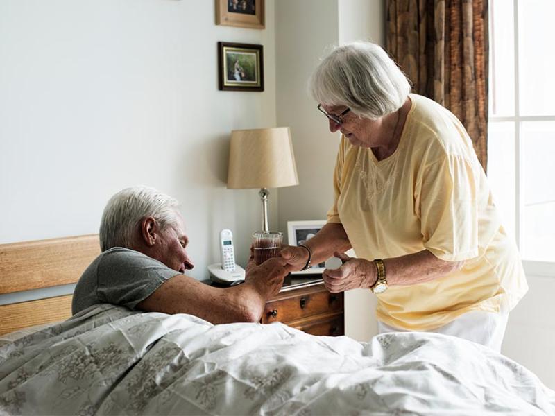 Una cuidadora ayudando a una persona mayor 