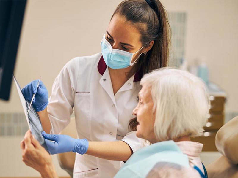 Una mujer mayor es atendida por una odontóloga en la consulta