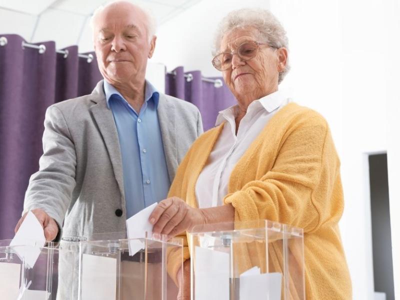 Un hombre y una mujer depositan sus votos en una urna