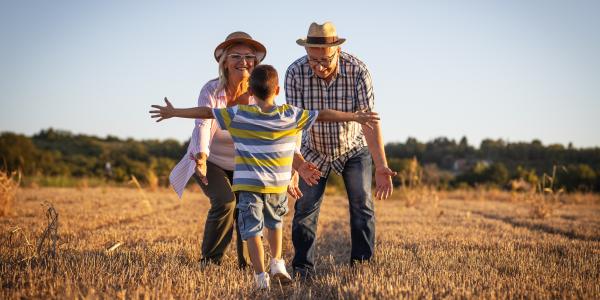 Un abuelo y una abuela con su nieto en el campo